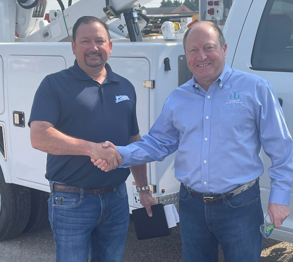 Ted Breidenbach and Mark Gehrt shake hands on the acquisition of Power Equipment Leasing.