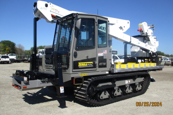 Custom tracked unit featuring a Terramac RT7U carrier, Versalift VST47 aerial lift, Alum-line flatbed, and Braden Winch, built for heavy-duty utility operations in tough terrains.