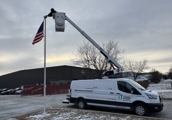 Versalift bucket truck setting a us flag